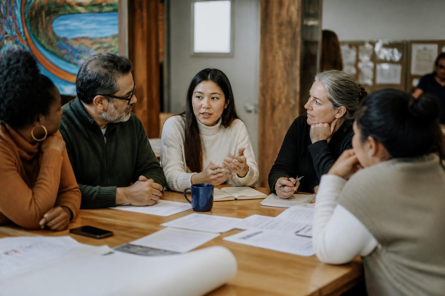 Community partners in a relaxed planning conversation around a shared table